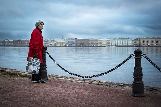 Възрастна жена край река Нева
